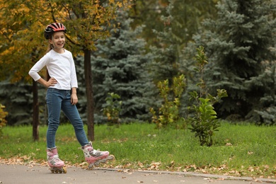 Cute girl roller skating in autumn park