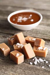 Photo of Yummy caramel candies with sea salt on wooden table, closeup