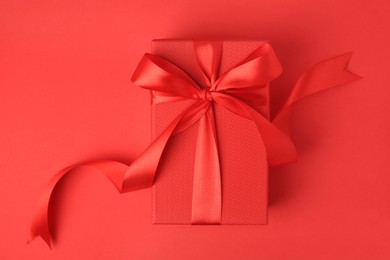 Photo of Beautiful gift box with bow on red background, top view