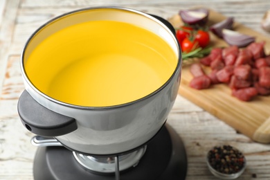 Fondue pot with oil for meat on table