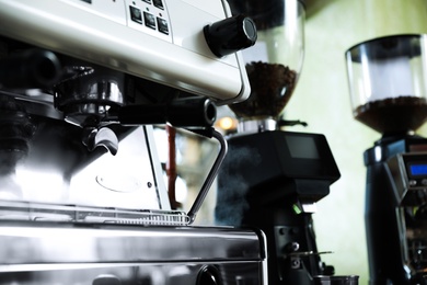 Photo of Modern coffee machine in cafe, closeup. Space for text