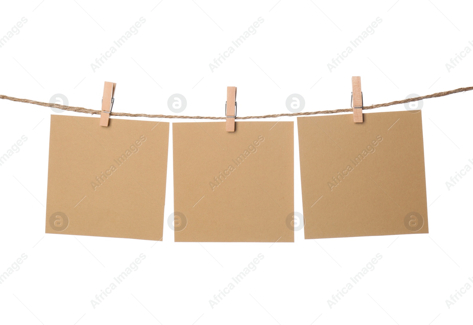 Photo of Clothespins with empty notepapers on string against white background. Space for text