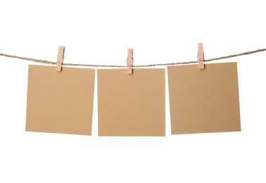 Clothespins with empty notepapers on string against white background. Space for text