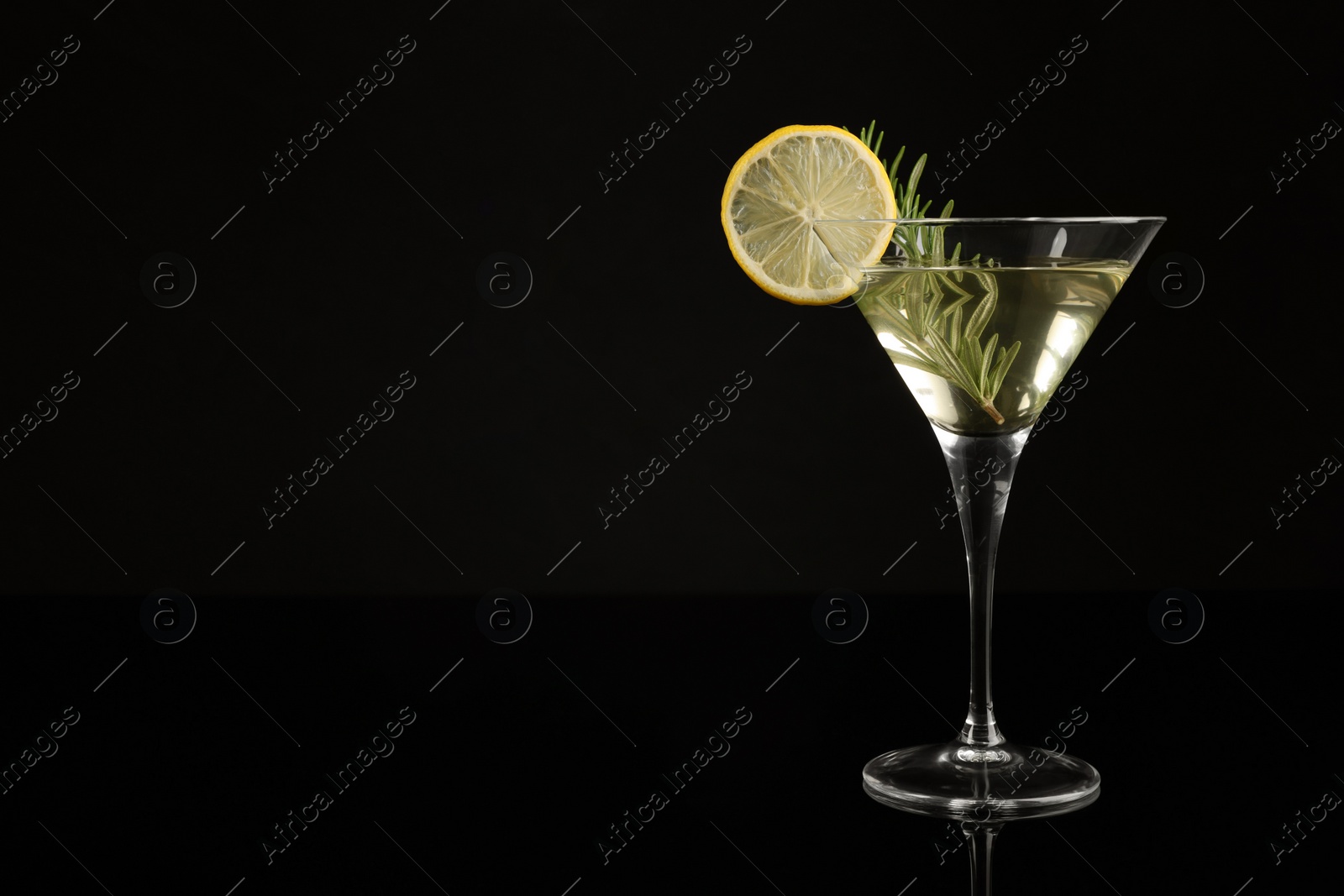 Photo of Martini cocktail with lemon slice and rosemary on black background, space for text