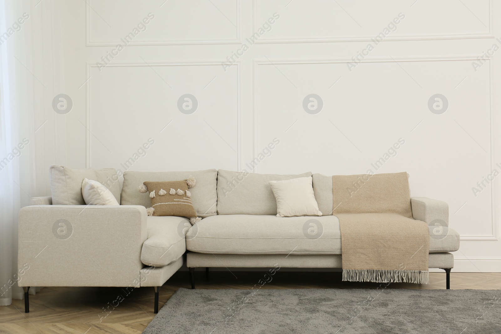 Photo of Comfortable sofa near white wall in living room