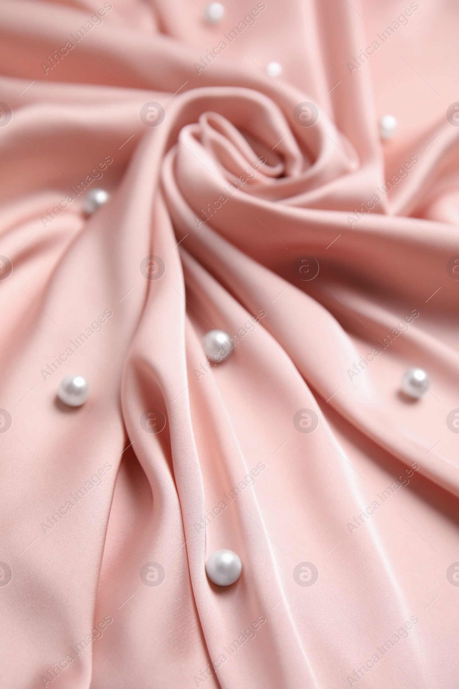 Photo of Many beautiful pearls on delicate pink silk, closeup