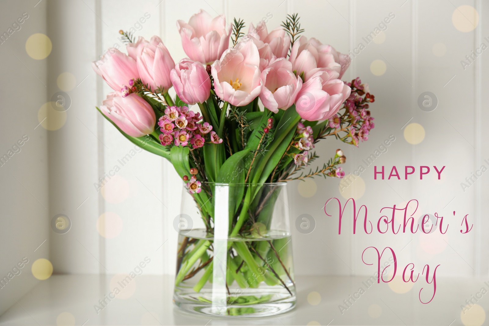 Image of Vase with beautiful tulips and phrase HAPPY MOTHER'S DAY on light table