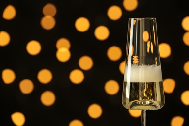 Photo of Glass of champagne against blurred lights. Space for text