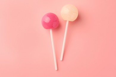 Tasty lollipops on pink background, flat lay