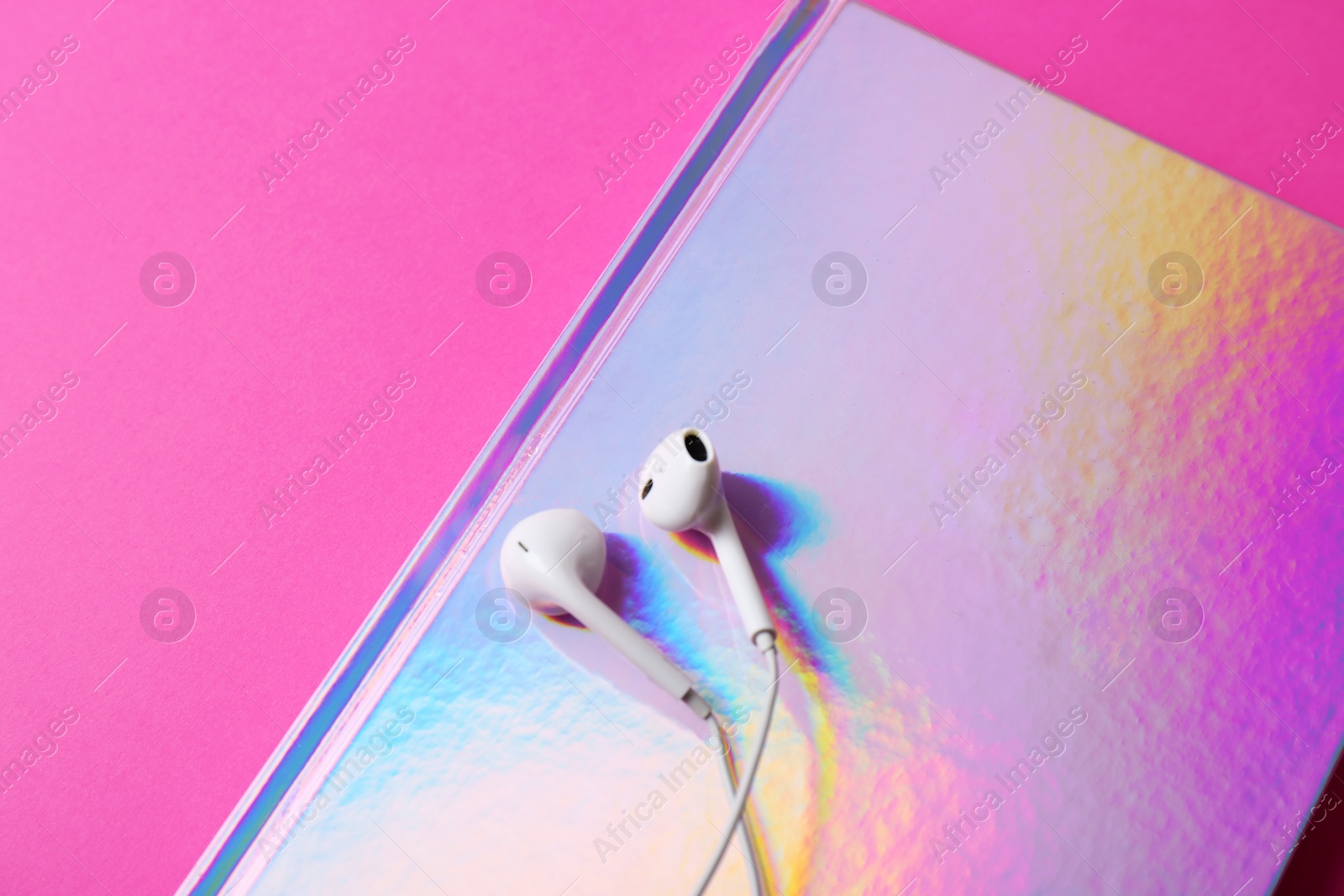 Photo of Stylish girl notebook and earphones on color background, closeup