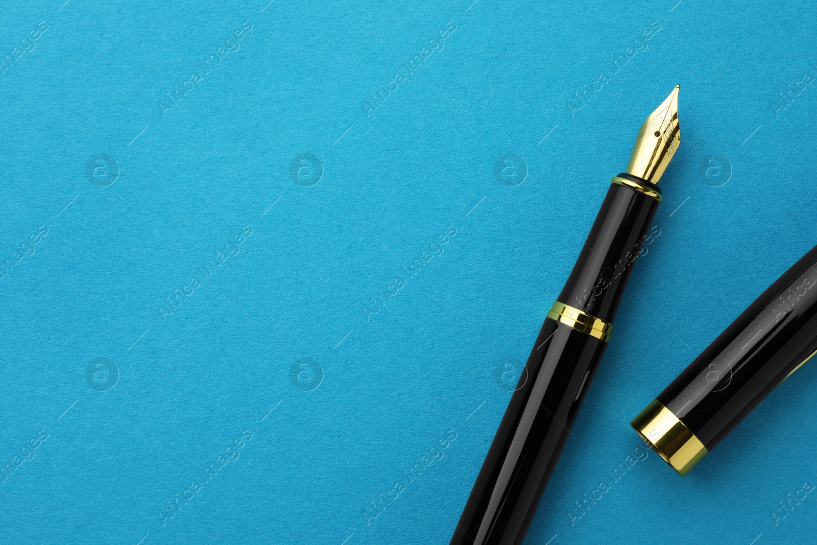 Photo of Stylish fountain pen with cap on light blue background, flat lay. Space for text