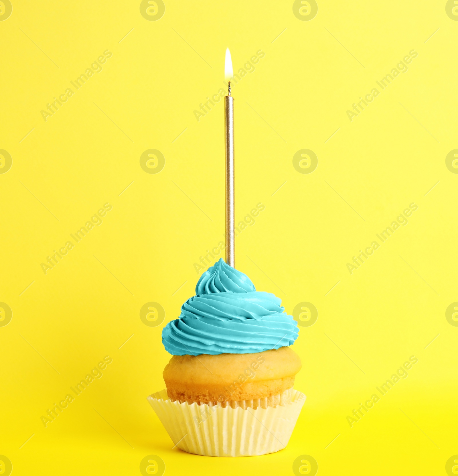 Photo of Birthday cupcake with candle on yellow background