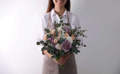 Photo of Florist holding beautiful wedding bouquet on white background, closeup