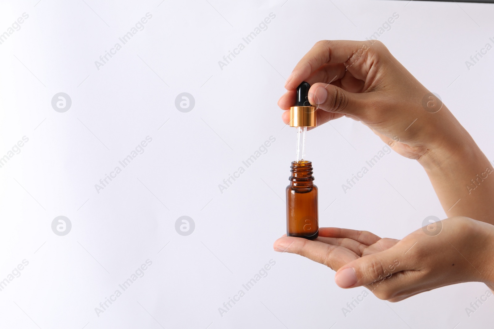 Photo of Woman with bottle of cosmetic serum and dropper on white background, closeup. Space for text
