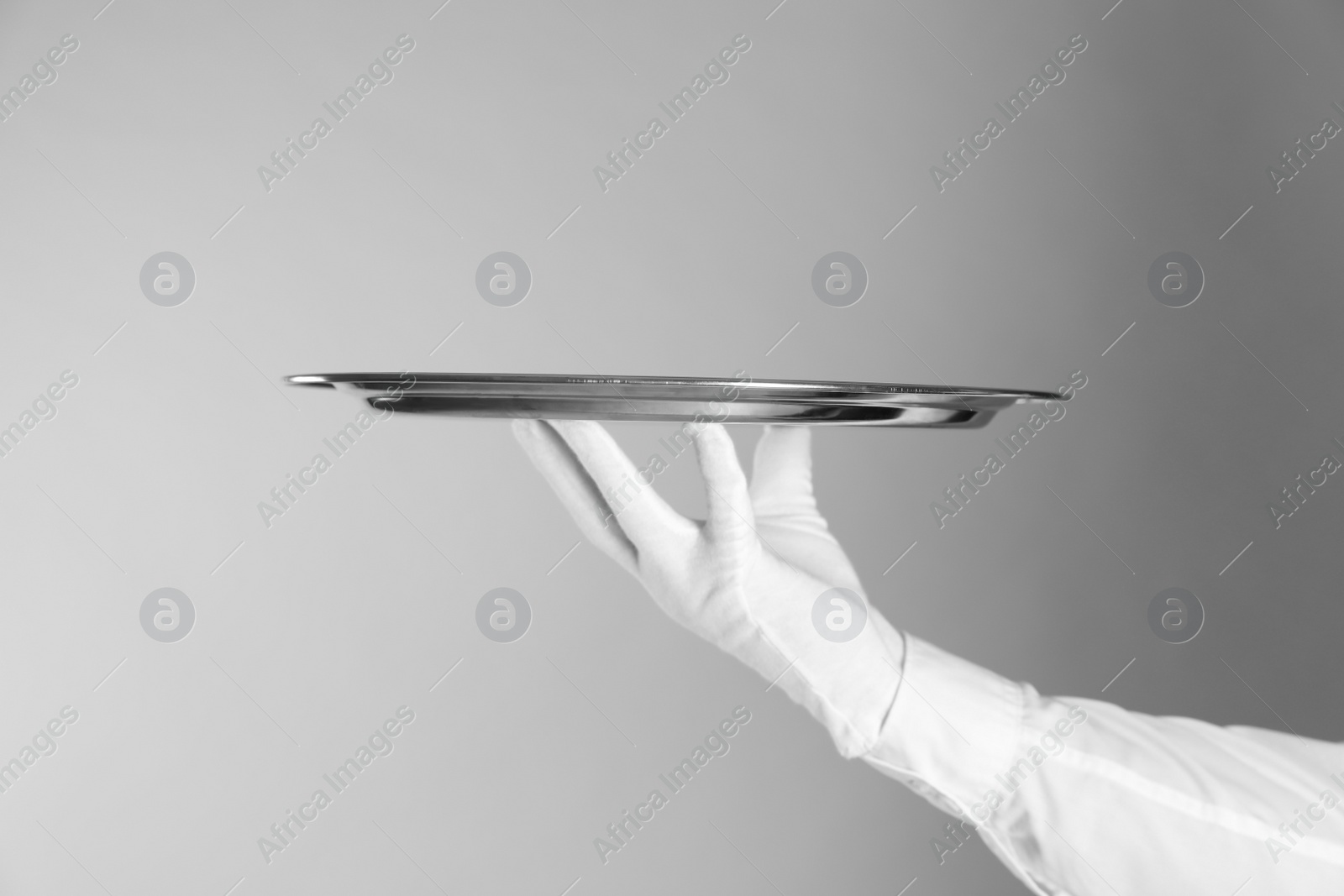 Photo of Butler with tray on light grey background, closeup