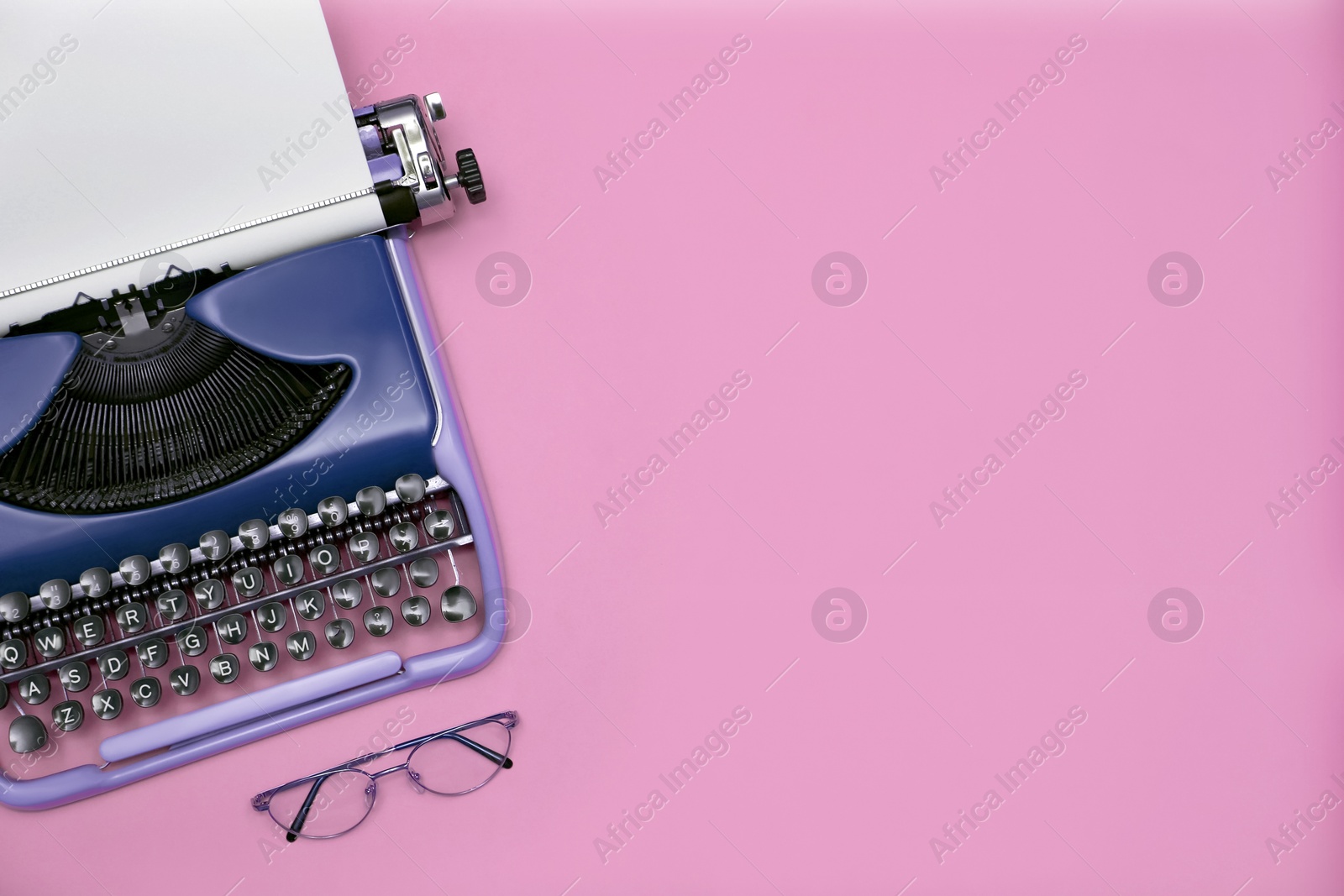 Image of Copywriter. Vintage typewriter and eyeglasses on pink background, top view. Space for text