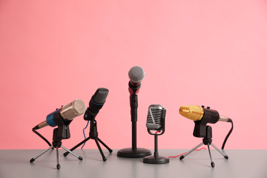 Photo of Microphones on table against pink background. Journalist's work