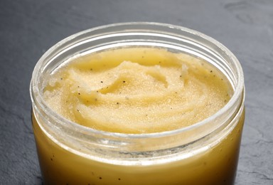 Body scrub in jar on dark table, closeup