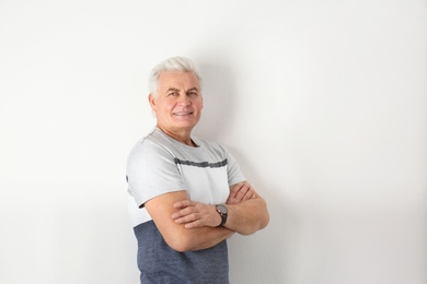 Portrait of handsome mature man on light background. Space for text