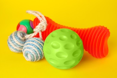 Photo of Various bright pet toys on yellow background