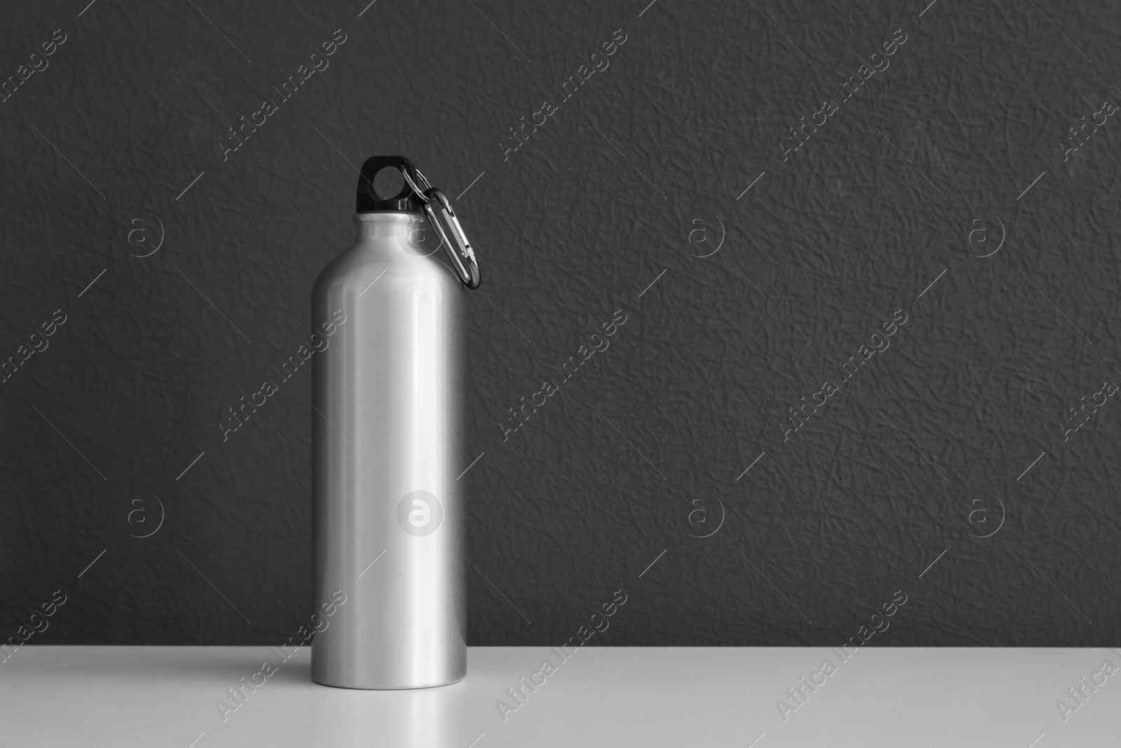 Photo of Aluminum water bottle for sports on gray background. Space for text