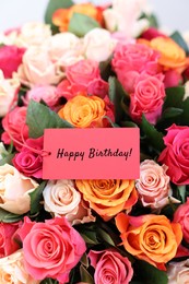 Image of Bouquet of beautiful roses with Happy Birthday card, closeup