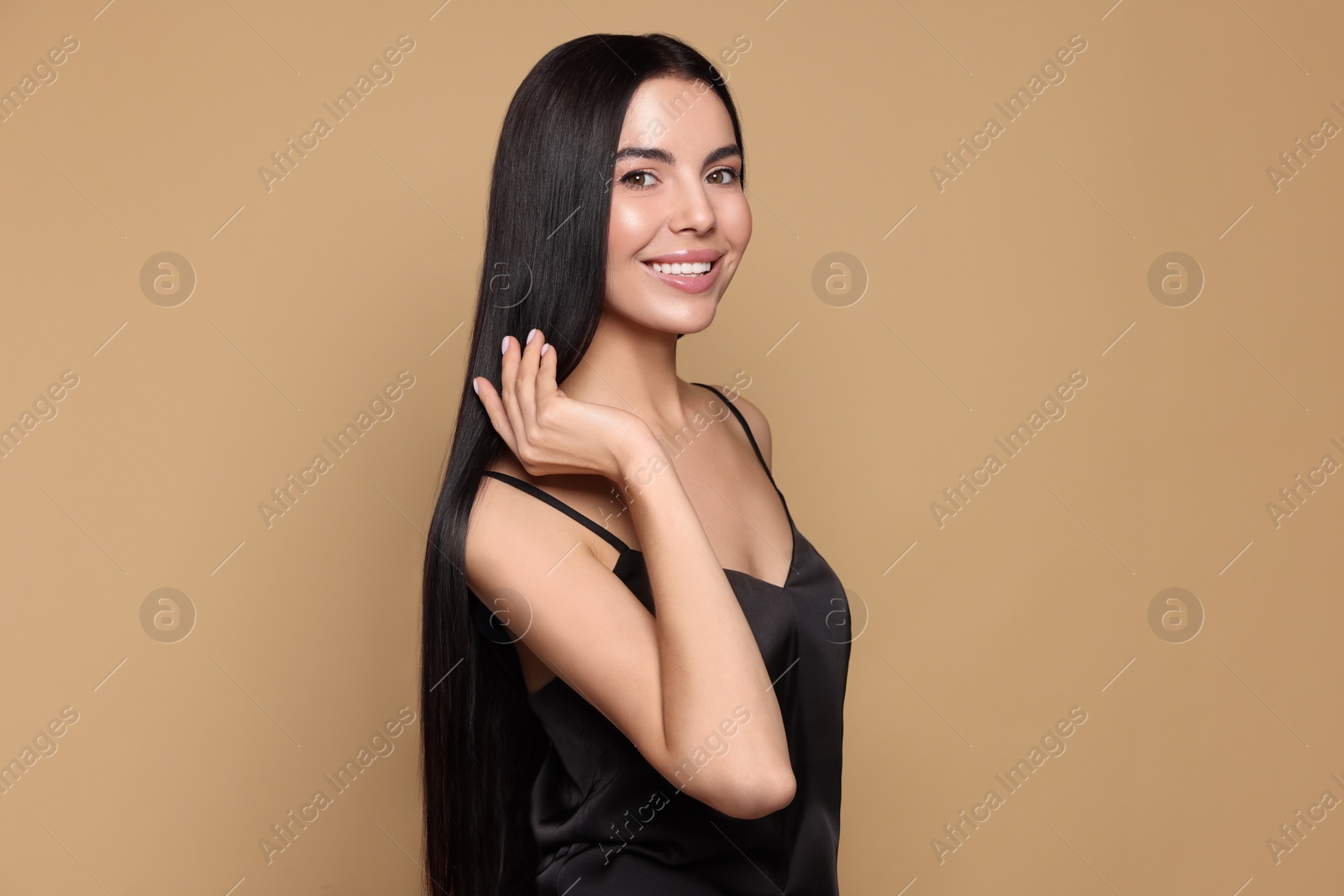 Photo of Portrait of beautiful young woman with healthy strong hair on beige background