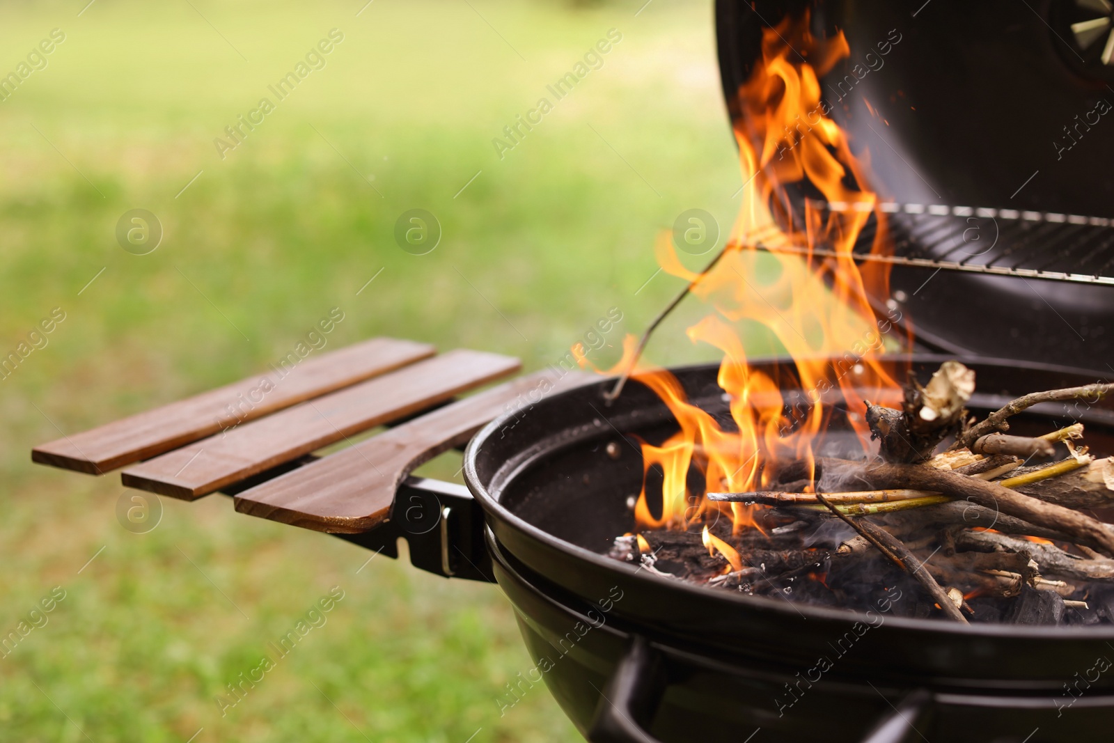 Photo of Modern barbecue grill with fire flames outdoors