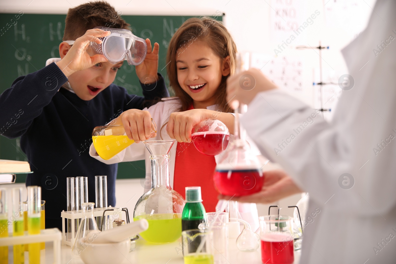 Photo of Smart pupils making experiment in chemistry class