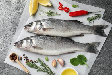 Photo of Sea bass fish and ingredients on grey table, top view