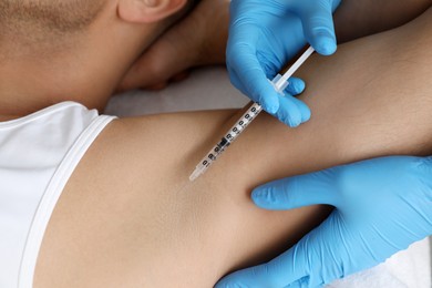 Photo of Cosmetologist injecting man's armpit, closeup. Treatment of hyperhidrosis