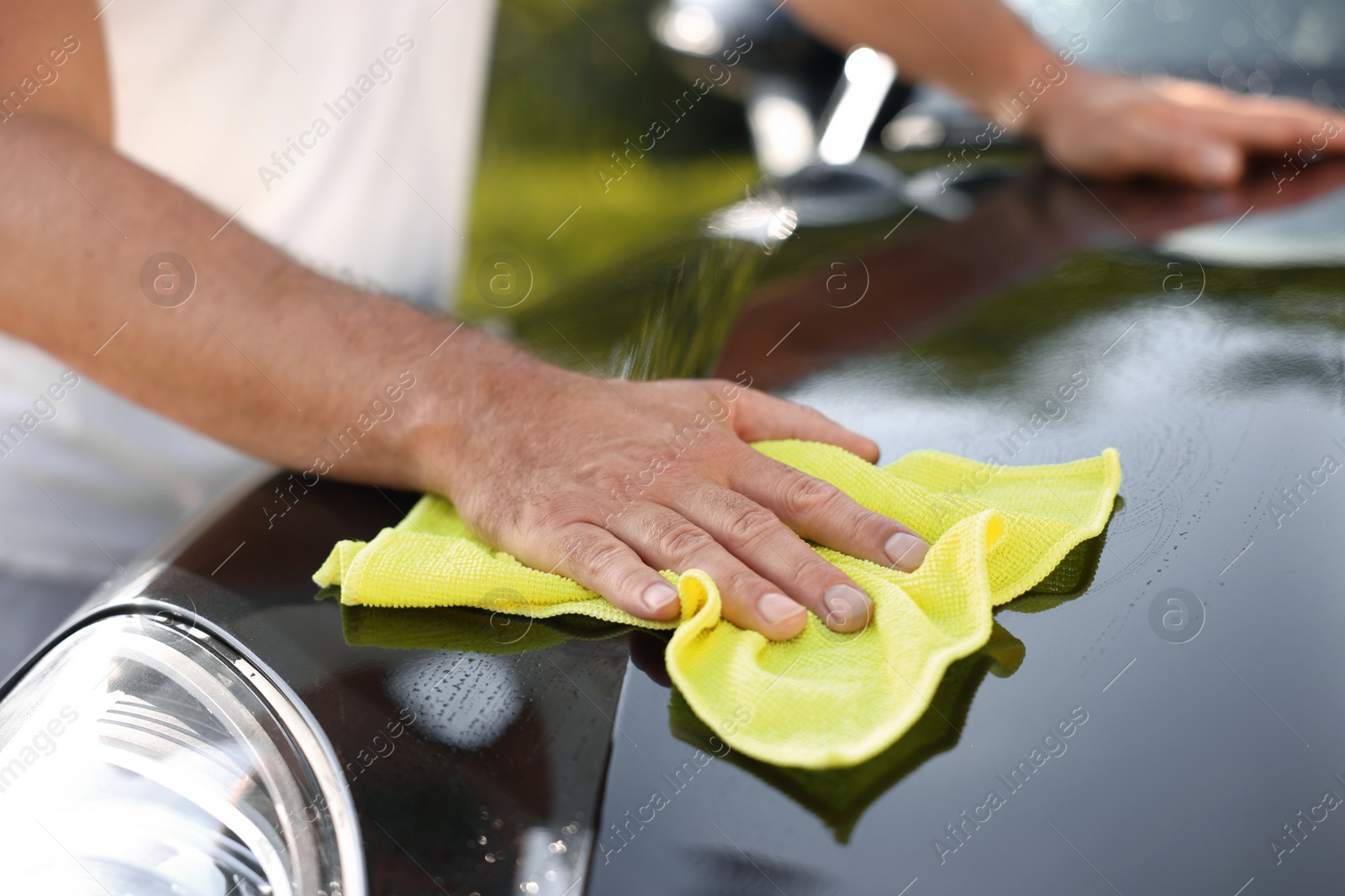 Photo of Man washing car hood with rag outdoors, closeup