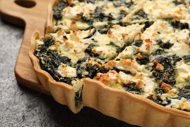 Delicious homemade spinach quiche on gray table, closeup