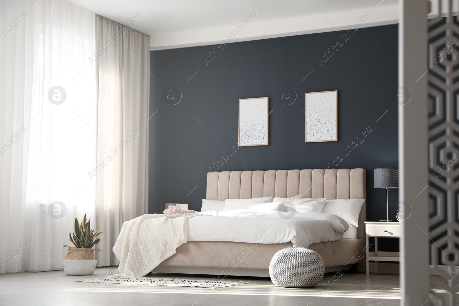 Photo of Comfortable bed with soft blanket in stylish room interior