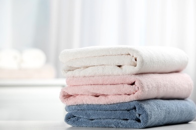 Photo of Stack of fresh soft towels on table