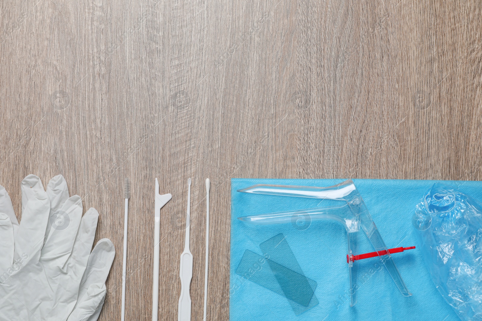 Photo of Gynecological examination kit on wooden table, flat lay. Space for text