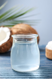 Photo of Coconut oil on blue wooden table, closeup view