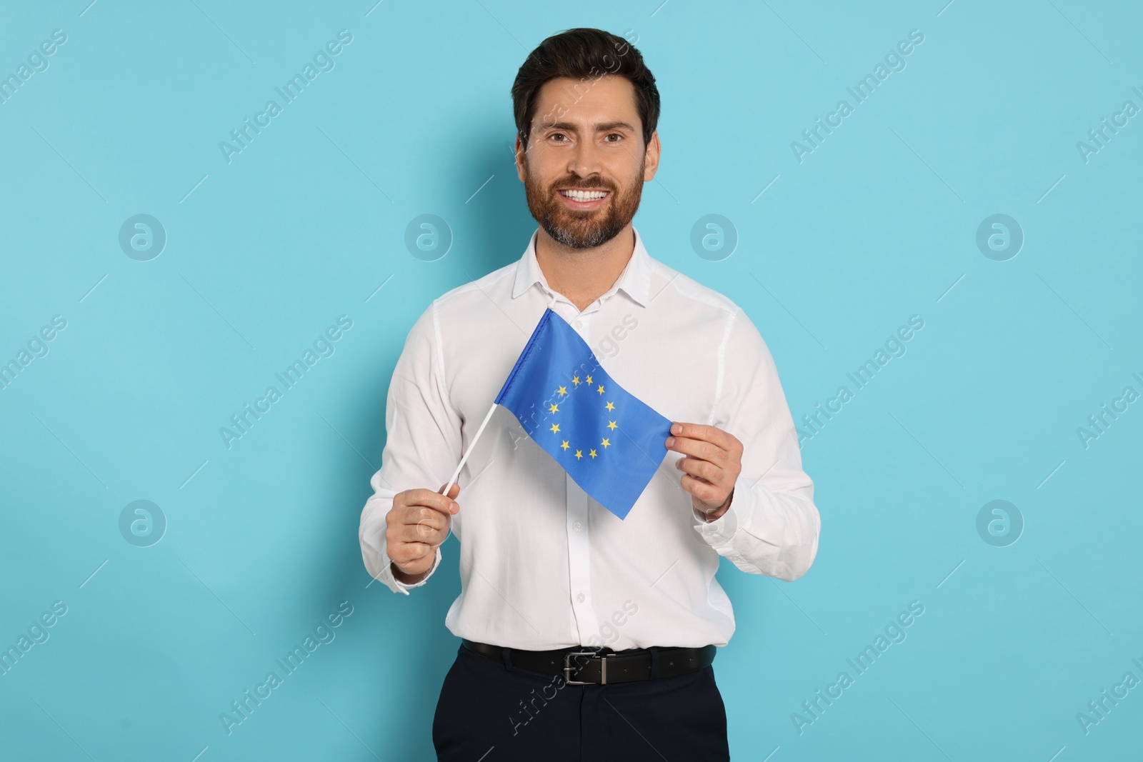 Photo of Man with flag of European Union on light blue background