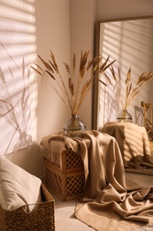 Photo of Vase with decorative dried plants and painting in stylish room interior