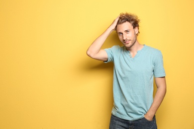 Young man in casual clothes posing on color background. Space for text