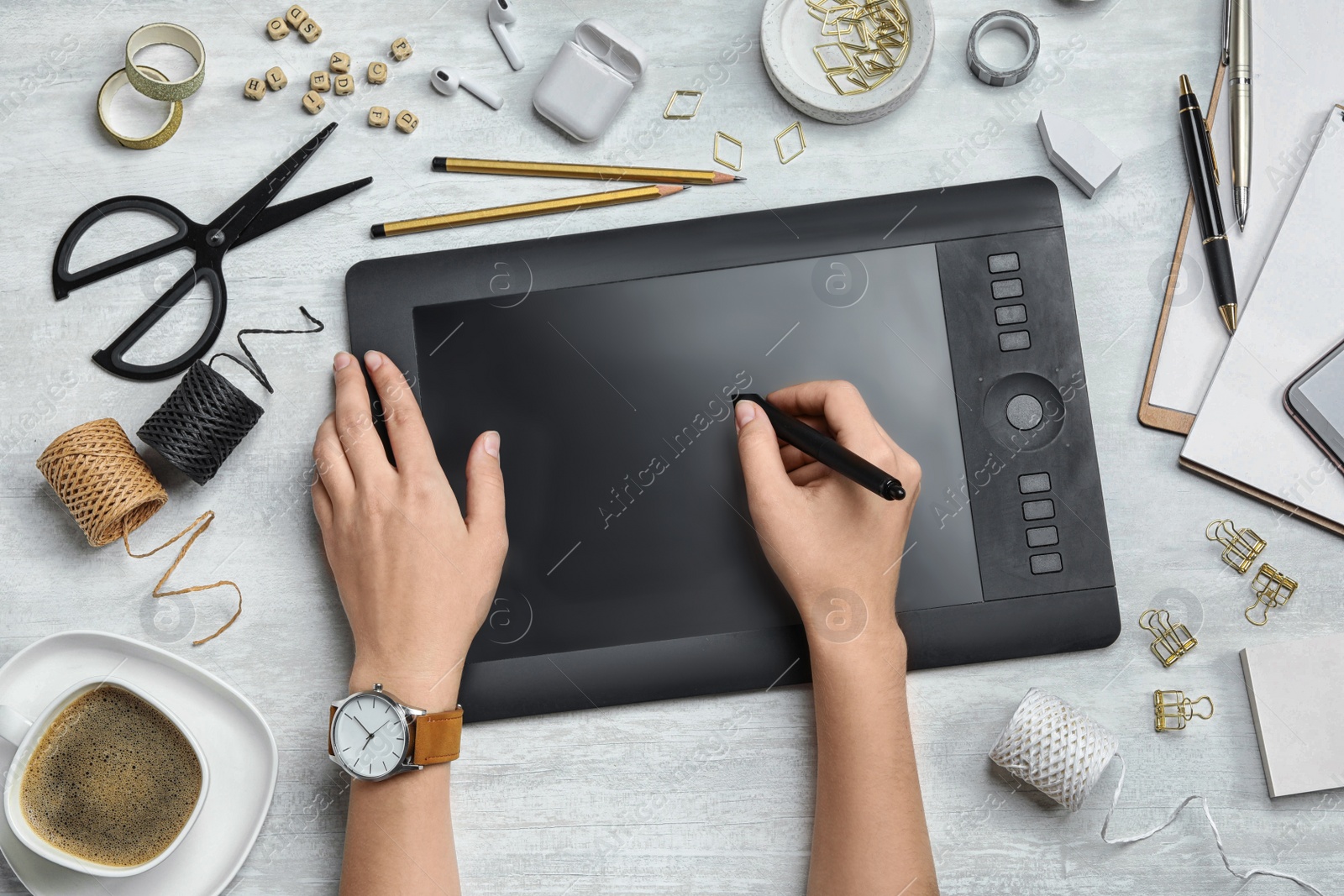 Photo of Female designer working with graphics tablet at white table, top view