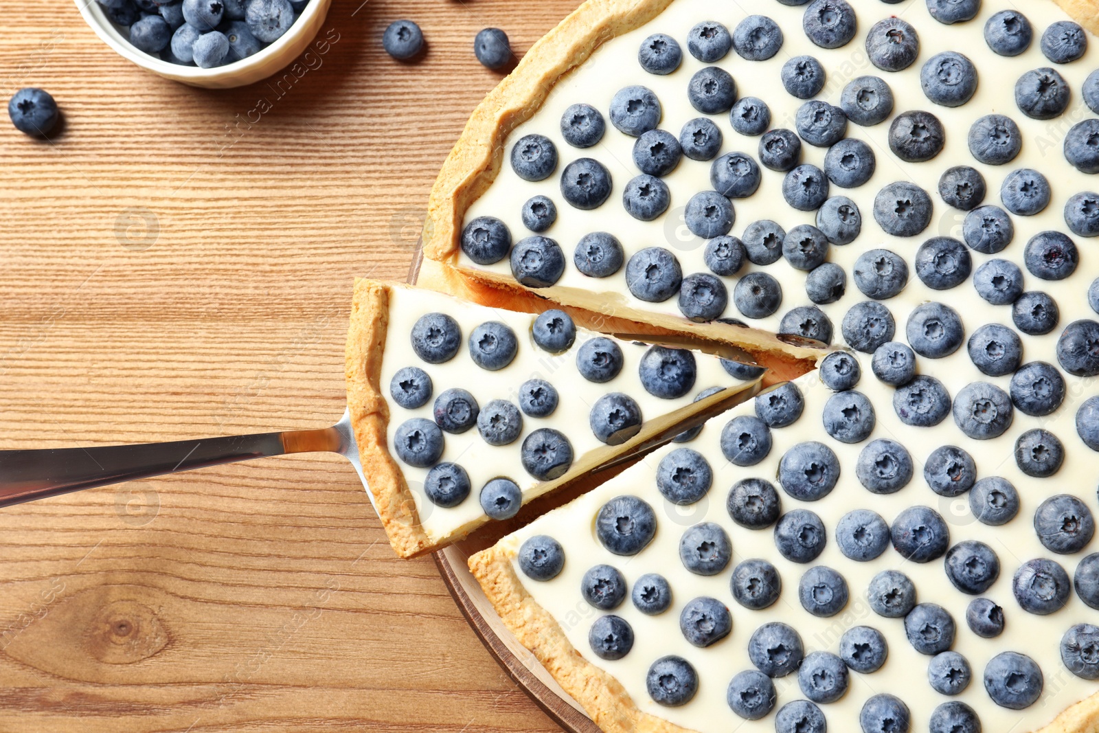 Photo of Flat lay composition with tasty blueberry cake on wooden table