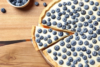Photo of Flat lay composition with tasty blueberry cake on wooden table