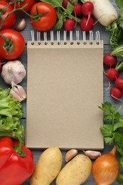 Photo of Blank recipe book and different ingredients on grey wooden table, flat lay. Space for text