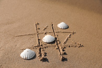 Photo of Playing Tic tac toe game with shells on sand