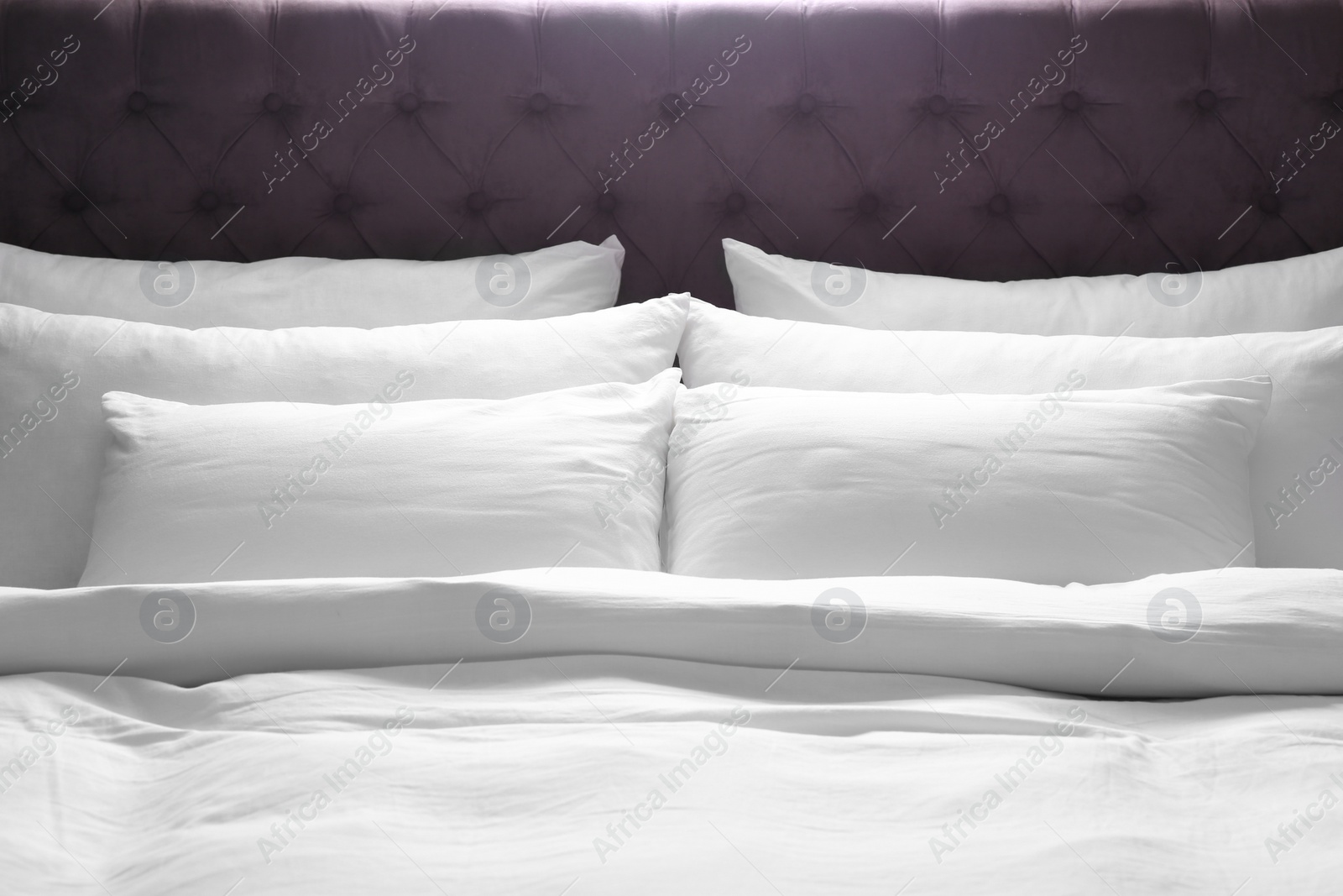 Photo of Modern bed with soft pillows in room