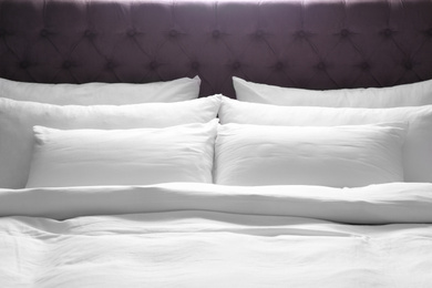 Photo of Modern bed with soft pillows in room