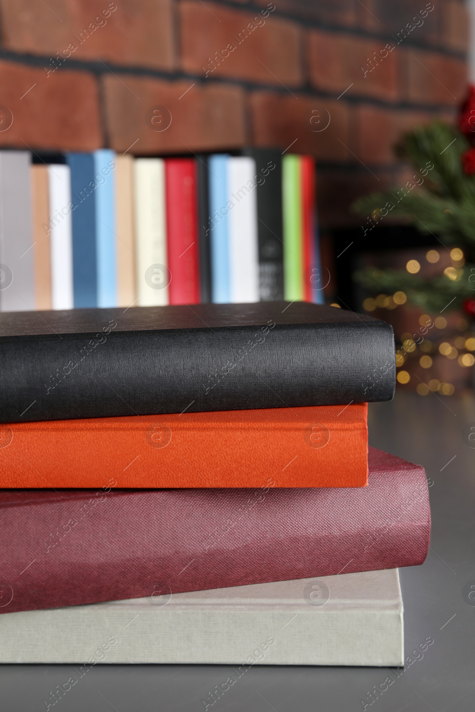 Photo of Stack of hardcover books on grey table indoors, closeup