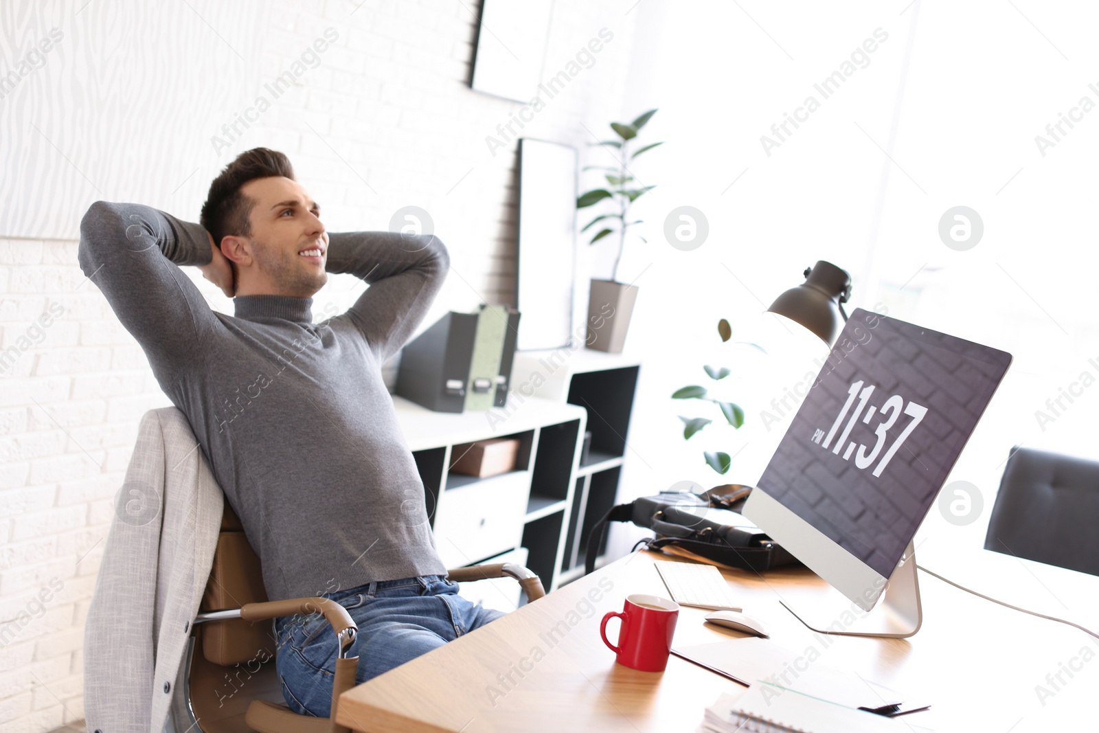 Photo of Young man relaxing at table in office during break