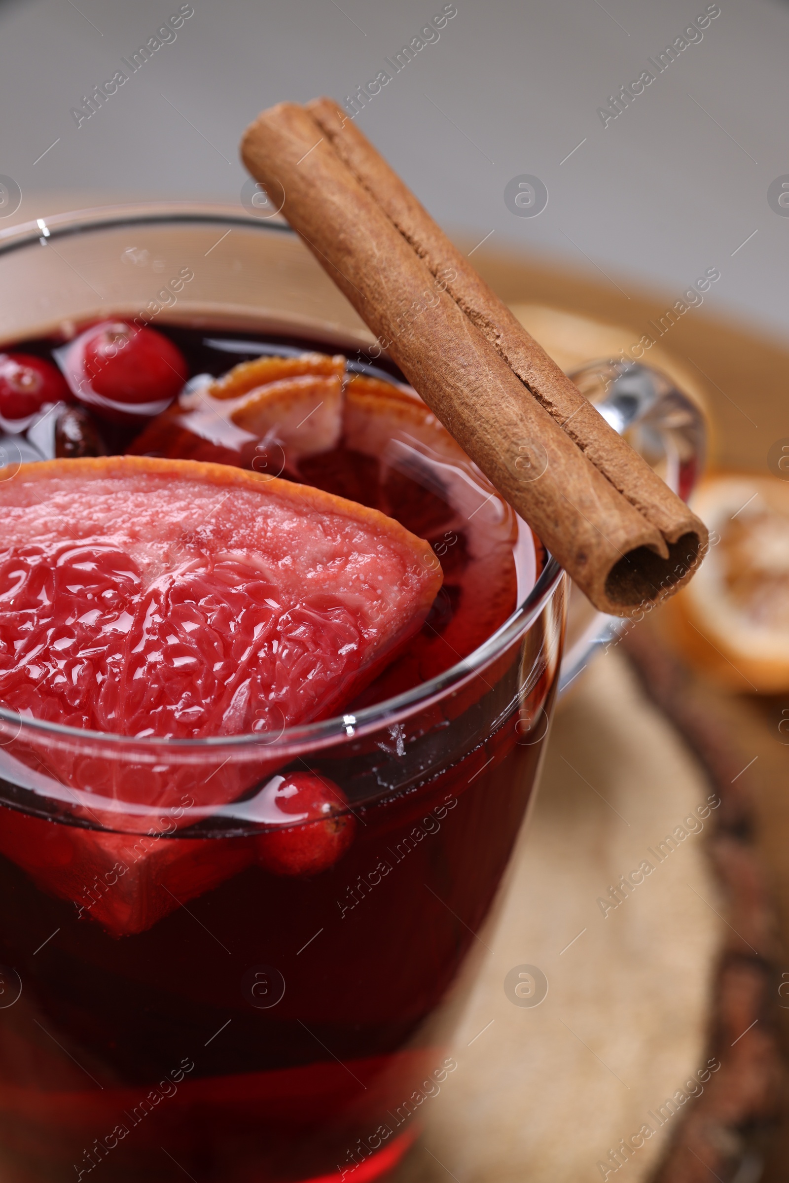 Photo of Aromatic mulled wine in glass cup on table, closeup